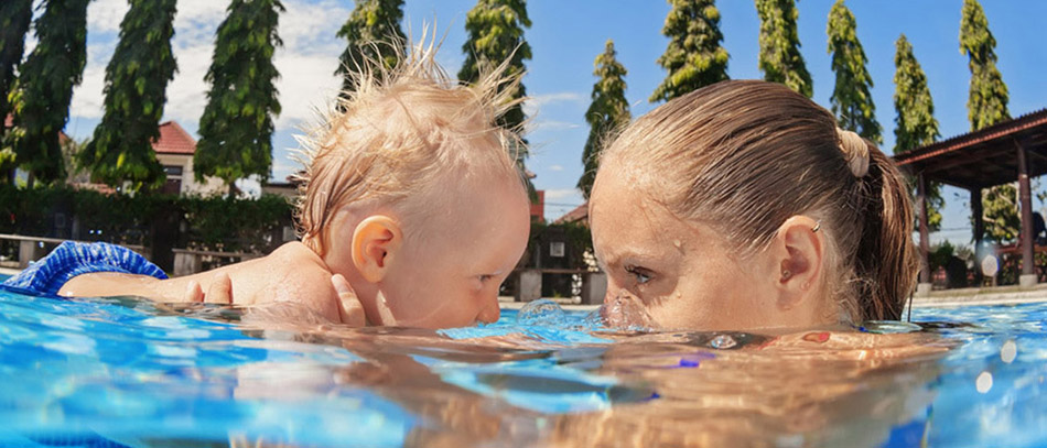 maman qui vient confier son enfant pour un cours de natation avec son enfant